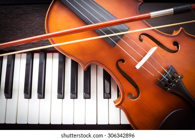 Violin and piano keyboard. Music background. Top view. Dark vignette.