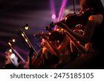 Violin players on stage. Live show with colorful stage lights and spotlights