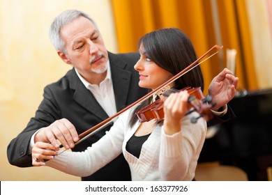 Violin Teacher Helping A Student