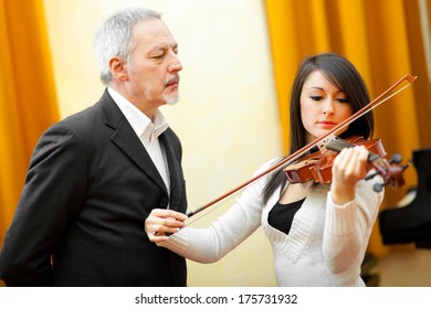 Violin Teacher Helping A Student 