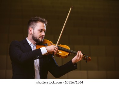 Violinist. Image of a man violinist in a concert hall. The young violinist wears a suit.