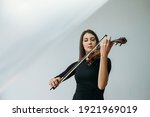 Violinist woman. Online education. Distance lesson. Lockdown reality. Inspired lady enjoying playing violin closed eyes with transparent plastic film under head isolated neutral copy space.