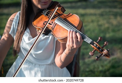 Violinist Woman. Young Woman Playing A Violin Outside.
