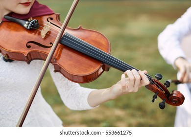 Violinist Woman. Young Woman Playing A Violin Outside.