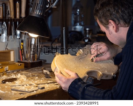 violn maker at work with new hand made violin carving table

