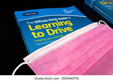 Viral face mask on top of The Official Highway Code, Official DVSA Guide to Learning to Drive and DVSA Guide to Driving books. Concept. Stafford, United Kingdom - August 30 2021.