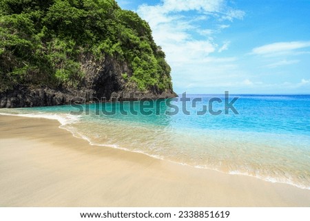 Virgin Beach or Pantai Pasir Putih (white sand beach) in Karangasem Regency, Bali, Indonesia with beautiful white sand, calm turquoise water and a rocky headland.