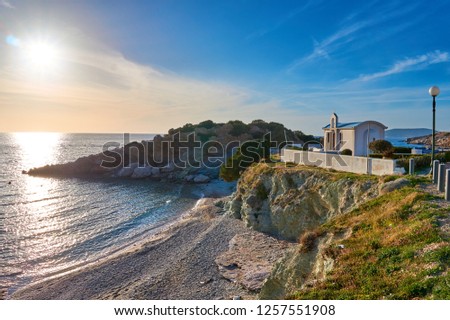 The Virgin Mary Katafigiotissa church at the coastal village of Palaia Fokaia in Eastern Attica, Greece. Scenic view of a traditional Greek Orthodox chapel next to the sea against a blue sky at sunset
