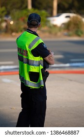 VIRGINIA, QUEENSLAND - SEPTEMBER 24, 2017: A Queensland Police Service Officer Stands Near A Large Industrial Fire At A Car Auto Parts Business.