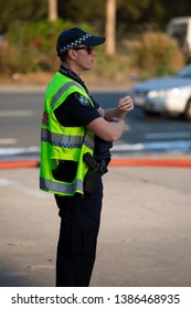 VIRGINIA, QUEENSLAND - SEPTEMBER 24, 2017: A Queensland Police Service Officer Stands Near A Large Industrial Fire At A Car Auto Parts Business.