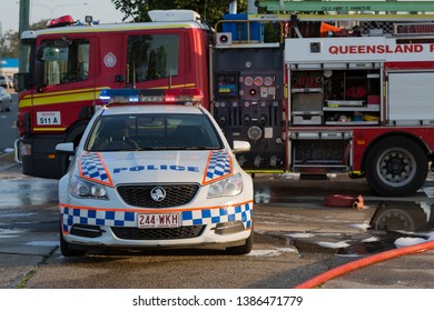 VIRGINIA, QUEENSLAND - SEPTEMBER 24, 2017: A Queensland Police Car Is Parked In Front Of A Queensland Fire Truck At The Scene Of A Large Industrial Factory Fire. 