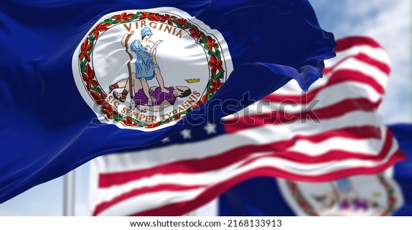 The\
Virginia state flag waving along with the national flag of the\
United States of America. Virginia is a state in the Mid-Atlantic\
and Southeastern regions of the United\
States