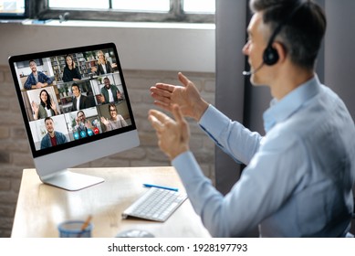 Virtuak business meeting online. Successful businessman is negotiating with multiracial business partners on a video conference using a computer while sitting at his workplace - Shutterstock ID 1928197793