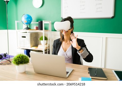 Virtual Classroom. Excited Young Teacher Wearing A VR Headset And Giving An Online Lesson Through Virtual Reality