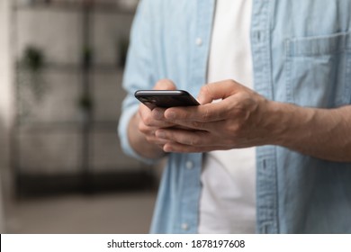 Virtual communication. Male hands holding new smartphone model touching sensor screen to browse internet. Close up of man viewing website social network connecting with shop bank chatting using cell