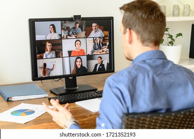 Virtual conference with employees. A young man in formal shirt using pc for video call, he has video meeting with several people together. Remote work concept - Shutterstock ID 1721352193