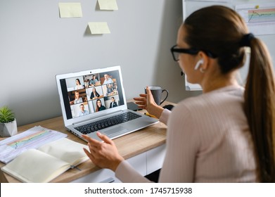 Virtuelle Konferenz, Online-Sitzung. Geschäftsfrau mit Laptop-App, um mit mehreren Leuten gleichzeitig zu kommunizieren. Zurück im Büro. Videoanruf mit Mitarbeitern
