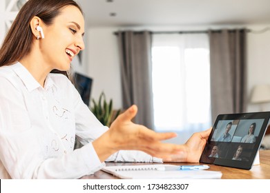 Virtual Conference, Online Meeting With Coworkers, Employees. A Young Woman In Home Office Is Using Tablet For Video Communication With Several People At Same Time Together
