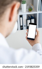 Virtual Connection. Digital Mockup. Work Place. Unrecognizable Man Holding Smartphone With Blank Screen In Hand Light Office Room Interior.