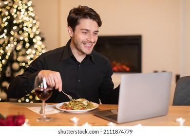 Virtual Date. Cheerful Bearded Guy Making Videocall With Friends, Girlfriend Or Wife During Dinner, Sitting At Dining Table Eating Pasta And Drinking Red Wine, Looking At Screen And Talking