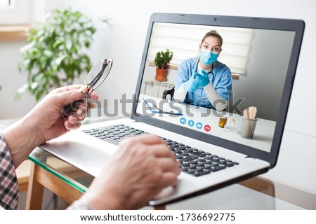 Virtual doctor visit,telemedicine healthcare concept,young female doctor giving advice over laptop computer screen to elderly woman,hands holding glasses  medical worker on display,remote appointment Foto stock © 