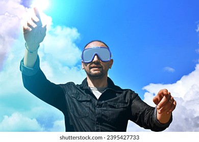 Virtual Experience. Excited Man Wearing VR Headset, Touching Air While Playing Video Game, Standing Over a blue sky Background, Panorama With Copy Space