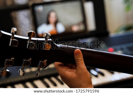 virtual guitar lesson. female musicians play together online in isolation because of the coronavirus pandemic