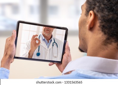 virtueller Live-Chat mit dem Patienten mit digitaler Tablette und einem Arzt via Internet. häusliche Pflege eines jungen männlichen Patienten in der Telemedizin oder Telehealth,