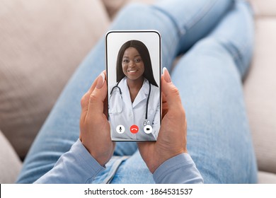 Virtual Medical Consultation. Sick Woman Talking With Doctor Online Via Video Call On Cellphone Sitting On Couch At Home. Nurse Consulting Patient From Smartphone Screen. POV