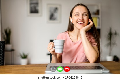 Virtual Meeting With A Friend. Video Chat With A Pretty Girl, He Sits At Home With A Cup Of Coffee In Hand And Looks At Camera With A Smile