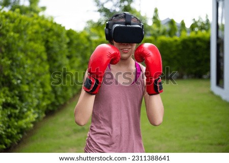 Virtual Metaverse. Young asian woman playing boxing game and workout in VR Headset. 