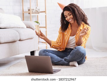 Virtual Party. Happy African American Woman In Hat Having Video Conference Online Meeting With Friends And Family, Holding Glass Of Wine, Toasting And Celebrating Birthday, Staying At Home