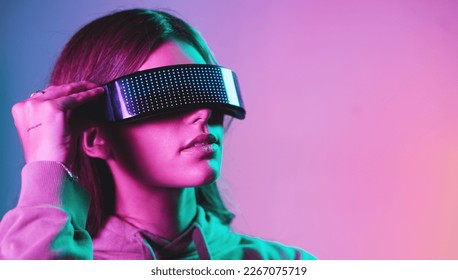 Virtual reality, cyberpunk and mockup, woman in goggles in online metaverse app, game or video on neon purple background. Vr, ar and ux, future fashion digital glasses on model in studio with space. - Powered by Shutterstock