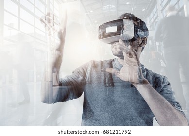 Virtual Reality Experience Conceptual Image With Young Men Wearing Modern VR Goggle At A Trade Fair