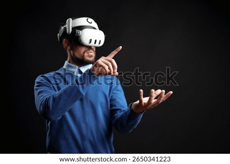 Virtual reality experience with a man interacting in a dark setting using advanced technology