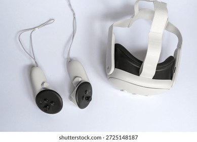 Virtual reality headset with motion controllers isolated on white background. Modern VR gaming equipment and immersive technology concept for metaverse, simulation, education and entertainment.