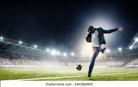 Virtual Reality Headset auf einem schwarzen Männchen, der Fußball spielt. Gemischte Medien