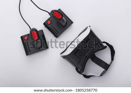 Virtual reality headset and retro joysticks on white background. Entertainment, video game. Top view