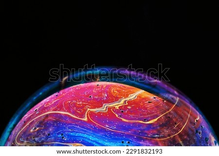 Virtual reality space with abstract multicolor psychedelic planet. Closeup Soap bubble like an alien planet on black background.