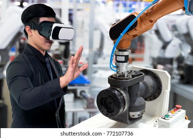 Virtual Reality Technology In Industry 4.0. Business Man Suit Wearing VR Glasses To See AR Service , Thermal Monitoring Motor For Check Destroy Part Of Smart Robot Arm Machine In Smart Factory.