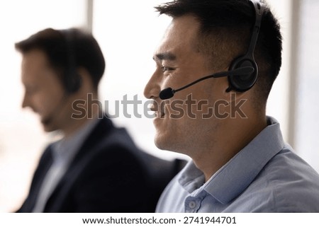 Virtual support. Head shot side portrait smiling young man hotline operator tech service agent in headphones with mic receive customer phone call give fast reliable assistance in modern service center