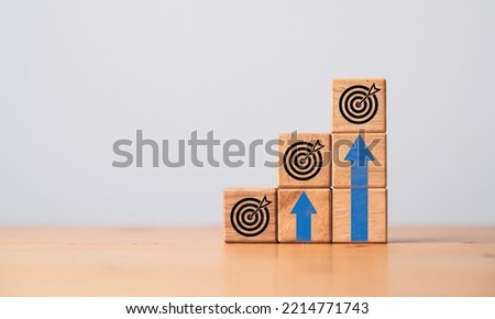 Virtual target board and up arrow which print screen on wooden cube. Enhance and setup business achievement goal and objective target concept.