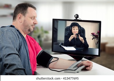 Virtual Therapist Carefully Watches Blood Pressure Figures Of Her Patient. She Wears Headset Because Working On-line. Middle-aged Man Uses Blood Pressure Gauge For Measurement In Front Of Doctor