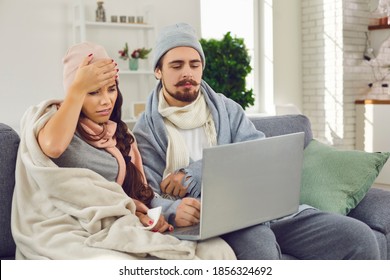 Virtual Visit To Doctor. Sick Young Couple Sitting On Sofa At Home, Having Online Medical Consultation Via Skype, Zoom Or FaceTime Video Call And Telling About Virus Infection And Flu Fever Symptoms