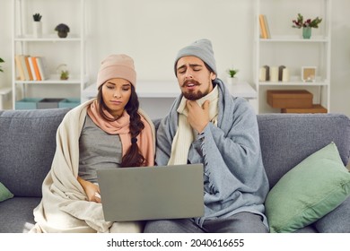 Virtual Visit To Doctor. Sick Young Couple Sitting On Sofa, Having Online Medical Consultation Via Skype, Zoom Or FaceTime Video Call, Complaining, Telling About Flu Virus Infection And Sore Throat