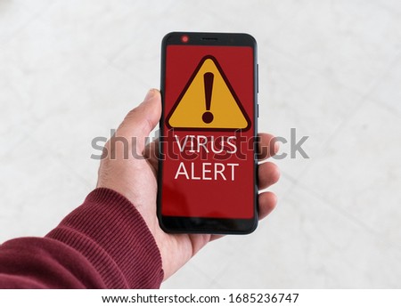 Virus alert message on red background on smartphone. Concept of warning in technology.