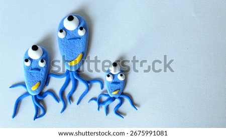 A virus or bacteria model made of modeling clay is isolated on a white background. The replica virus or bacteria is colored blue.