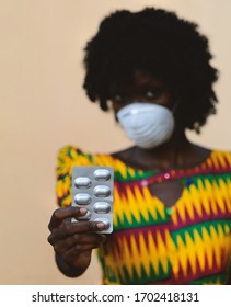 Virus Crisis around the world: African Woman Upper Body Shot with Mask and Medicament Pills