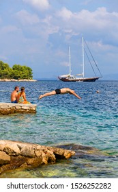 VIS, VIS ISLAND, CROATIA - SEPTEMBER 8, 2019: Athletic Older Man Jumping Into The Water In The Adriatic Sea