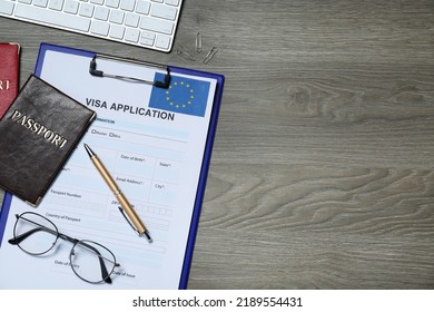 Visa application form for immigration to European Union, passports and glasses on wooden table, flat lay. Space for text - Shutterstock ID 2189554431
